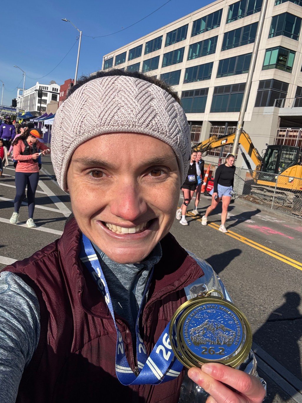 Julie Zack smiling and showing her Seattle Marathon finisher's medal